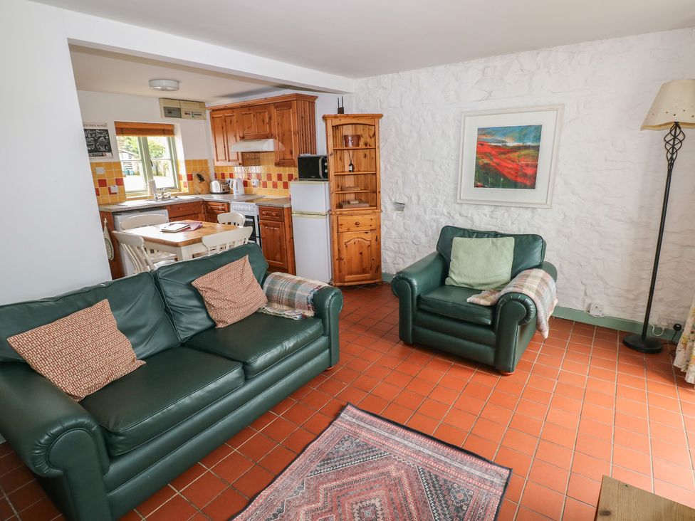 A living room with a sofa and armchair at Swallow Cottage in Cowbridge