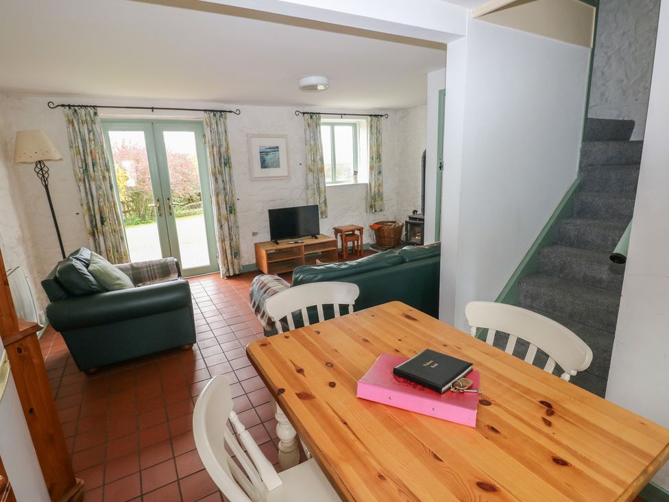 A living room with a dining table and chairs at Swallow Cottage in Cowbridge