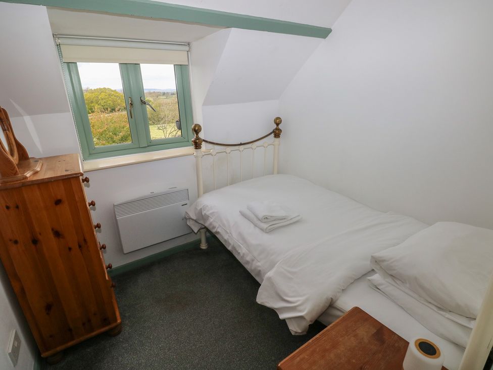 A bedroom with a single bed and window at Swallow Cottage in Cowbridge