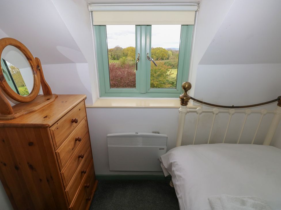 A bedroom with a window and furniture at Swallow Cottage in Cowbridge