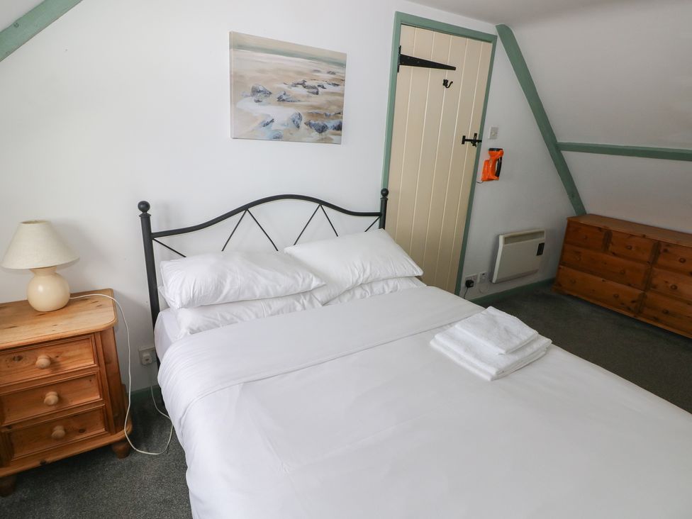 A bedroom with a bed and nightstand at Swallow Cottage in Cowbridge