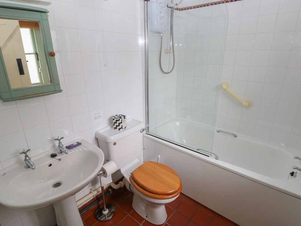 A bathroom with a bathtub, washbasin, and toilet at Swallow Cottage in Cowbridge