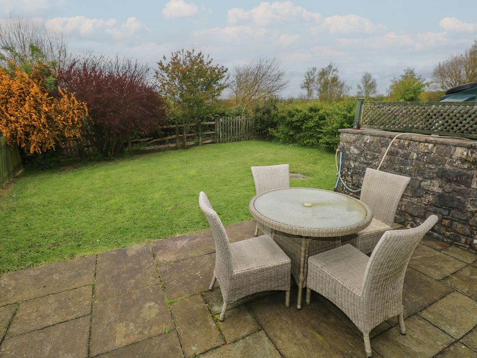 A garden with a table and chairs at Swallow Cottage in Cowbridge