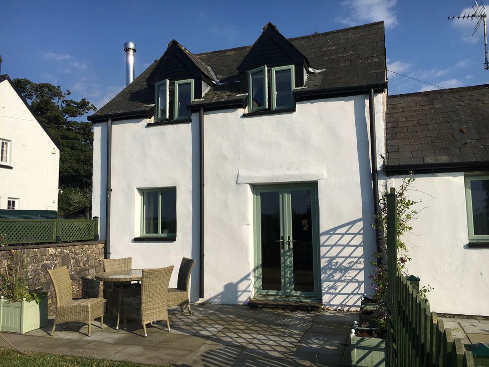 A house with a table and chairs outside at Swallow Cottage near Cowbridge