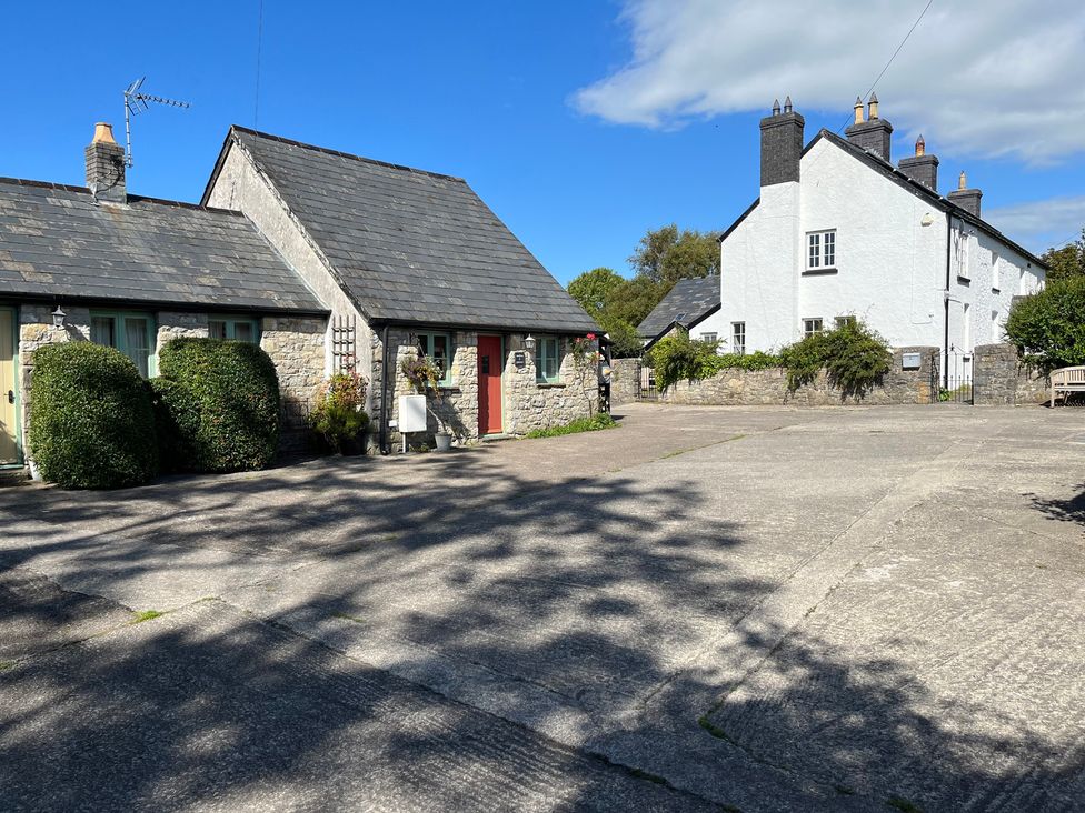 A cottage and a house in an outdoor area at Swallow Cottage near Cowbridge