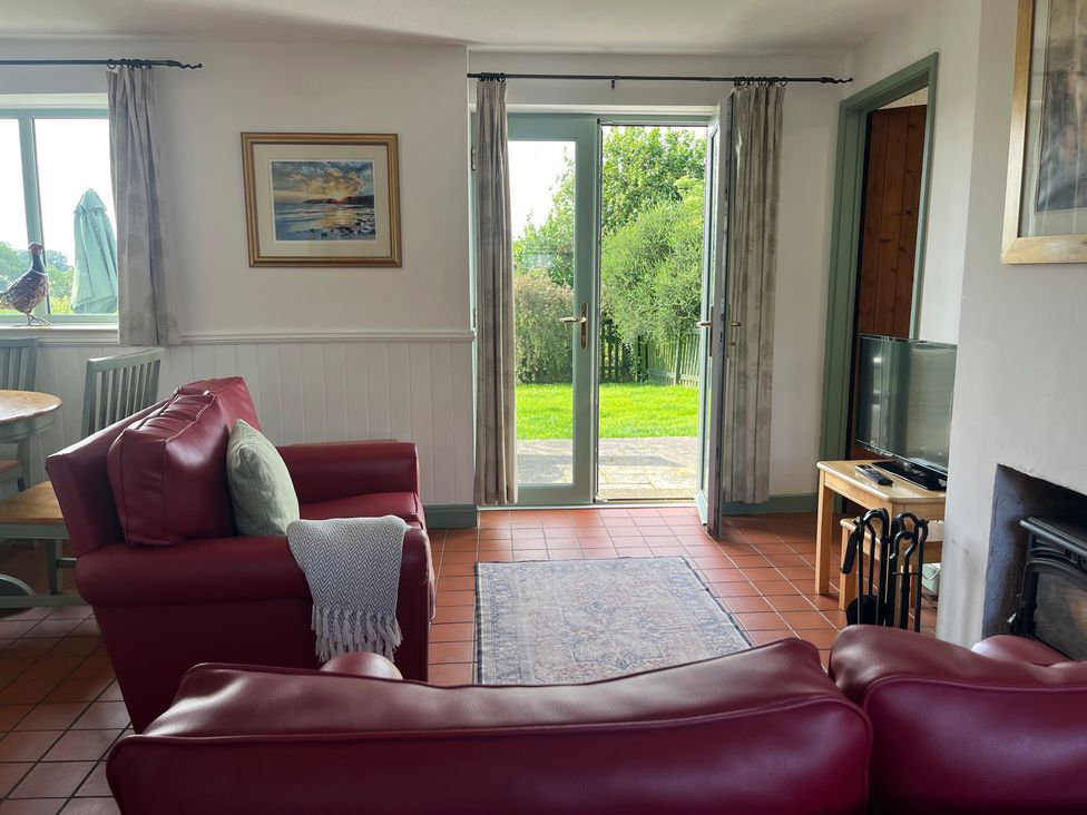 A living room with a sofa, table and TV at Wren Cottage in Cowbridge