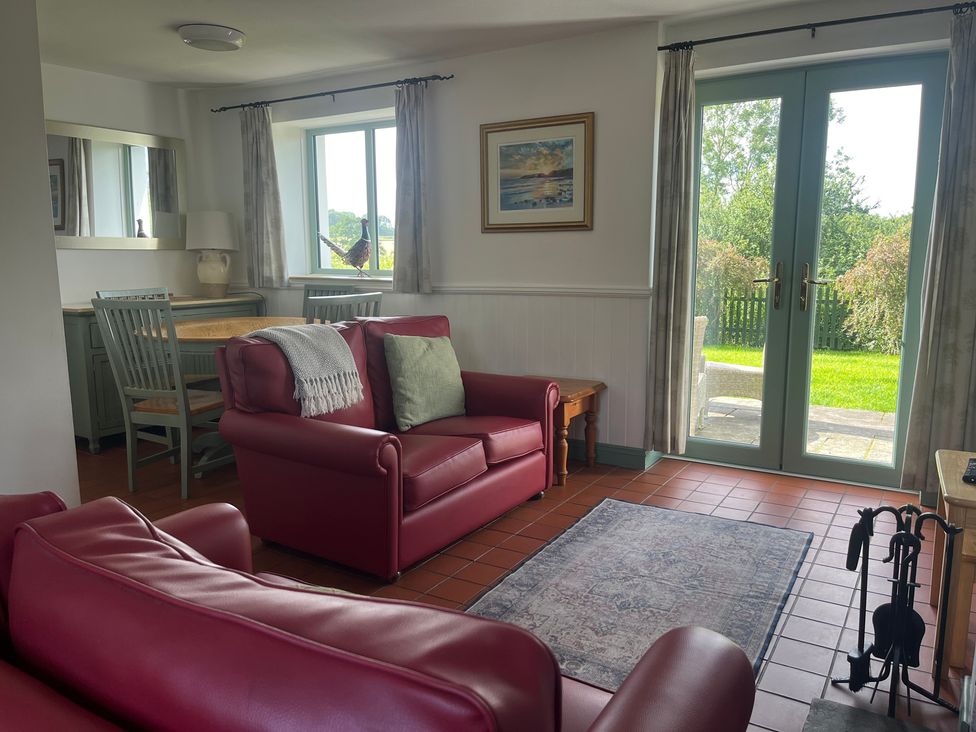 A living room with a sofa and dining table at Wren Cottage in Cowbridge