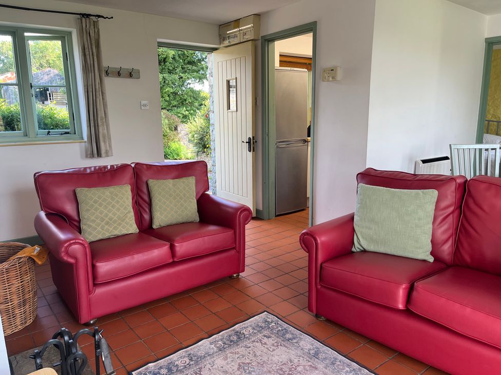A living room with sofas and a door leading to the kitchen at Wren Cottage in Cowbridge