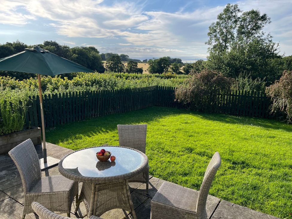 A garden with a table and chairs at Wren Cottage in Cowbridge