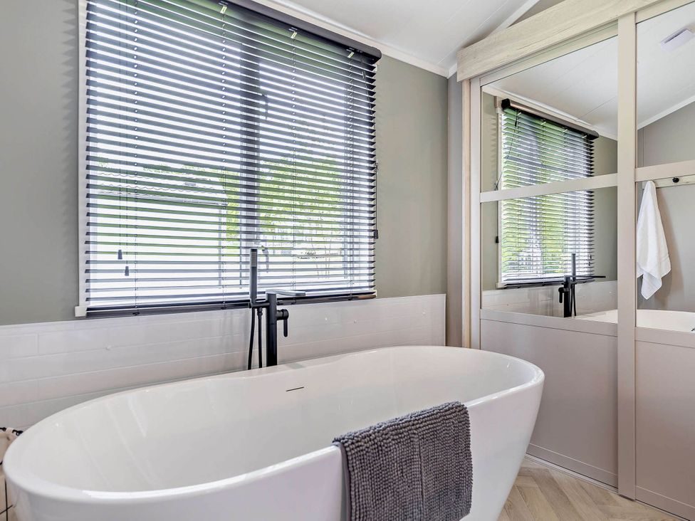 A bathroom with a bathtub and a window at Prion 1.0 Pet in Llandyrnog