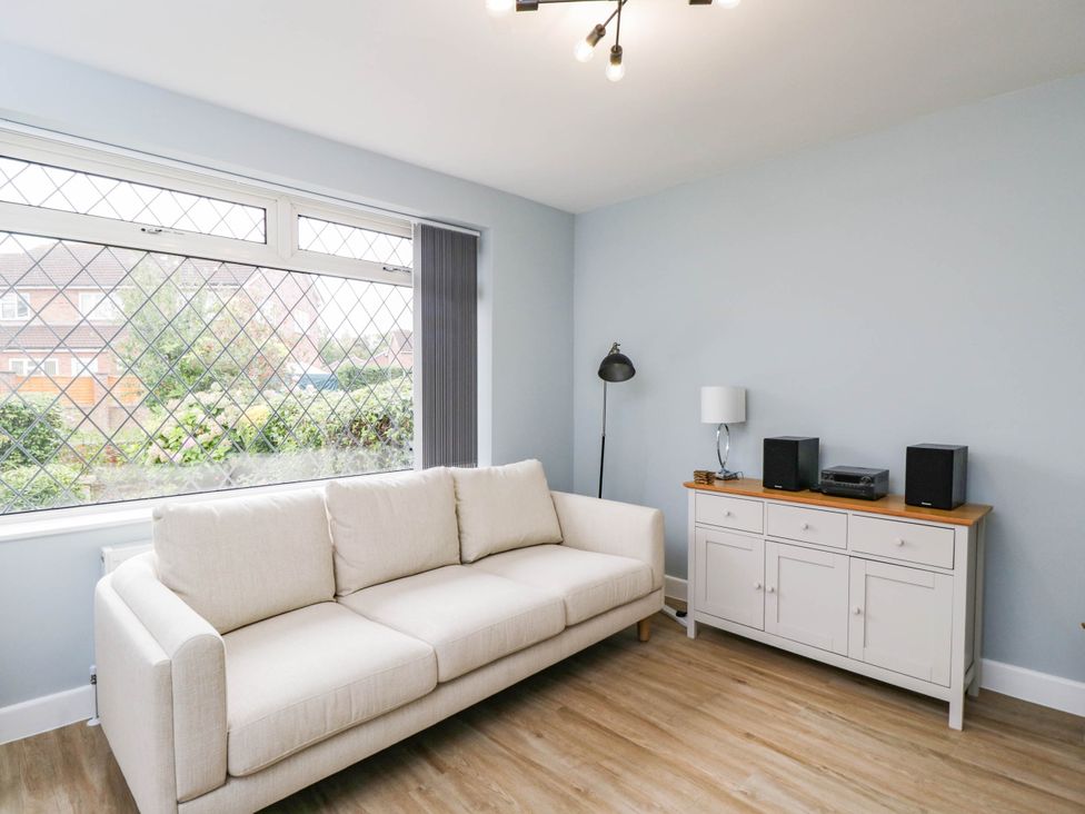 A living room with a sofa and media console at 3 Station Road Weston-Super-Mare