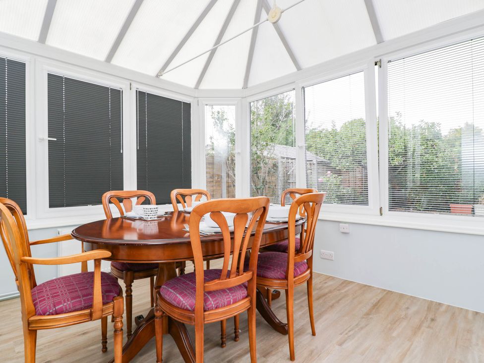 A conservatory with a dining table and chairs at 3 Station Road Weston-Super-Mare