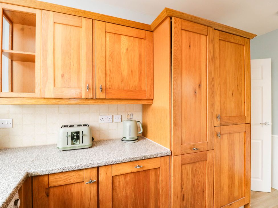 A kitchen with wooden cabinets and appliances at 3 Station Road Weston-Super-Mare