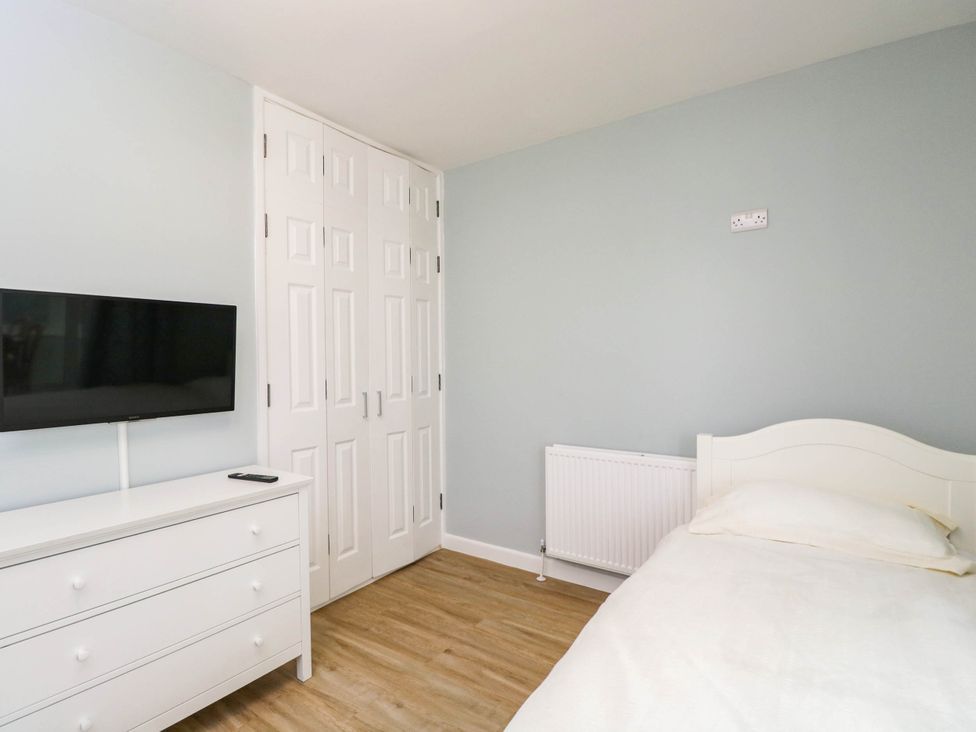 A bedroom with a bed, dresser, and television at 3 Station Road Weston-Super-Mare