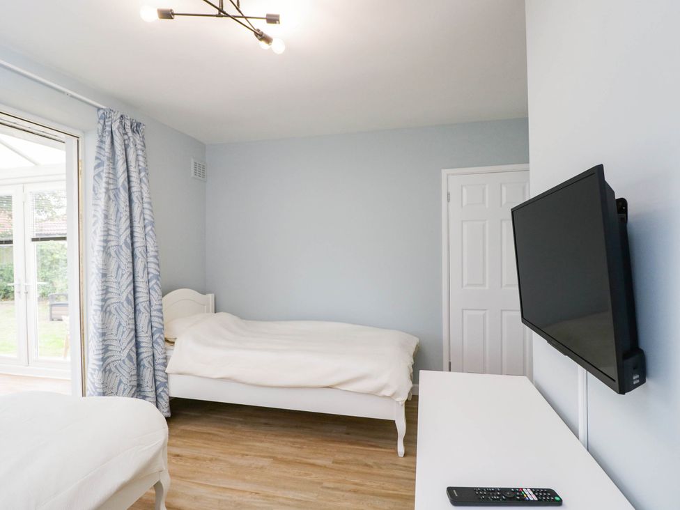 A bedroom with a bed and television at 3 Station Road Weston-Super-Mare