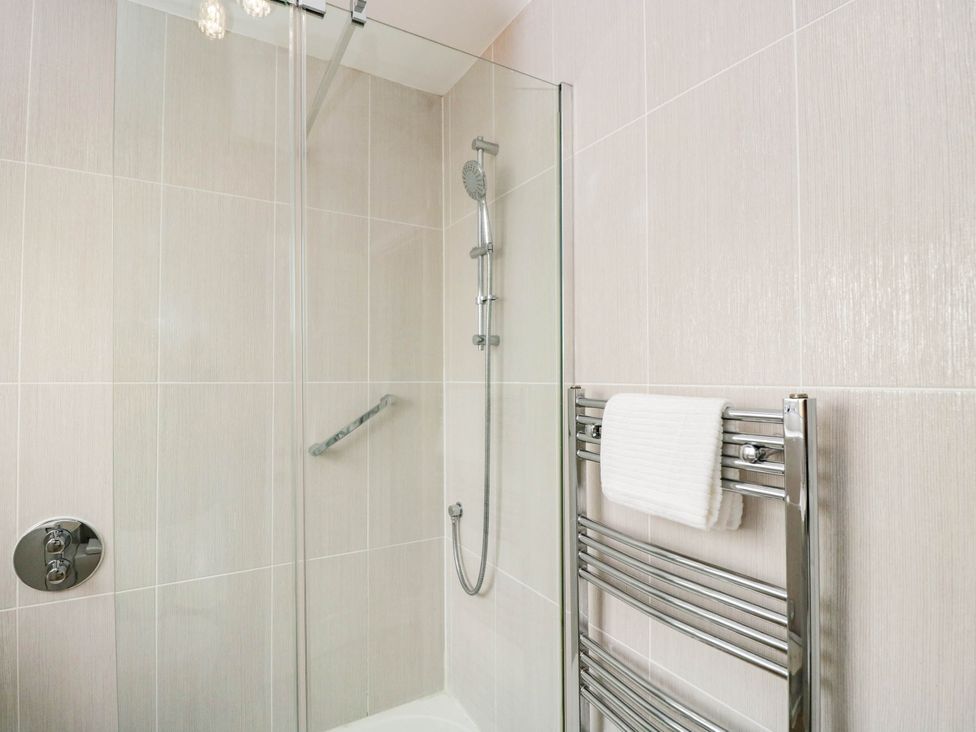A shower with a towel radiator and towel at 3 Station Road Weston-Super-Mare