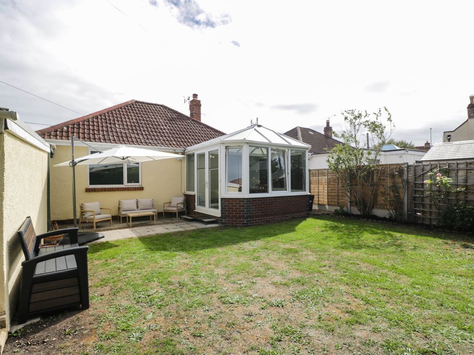 A garden with a conservatory and seating area at 3 Station Road Weston-Super-Mare