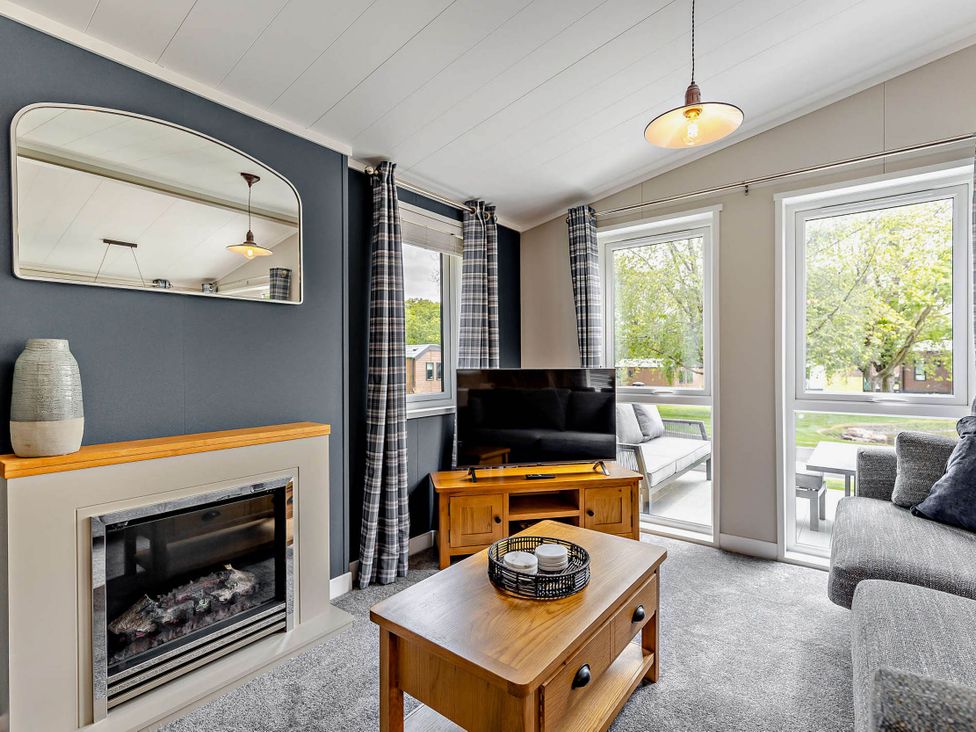 A living room with a sofa and fireplace at Elwy 3.0 Pet in Llandyrnog