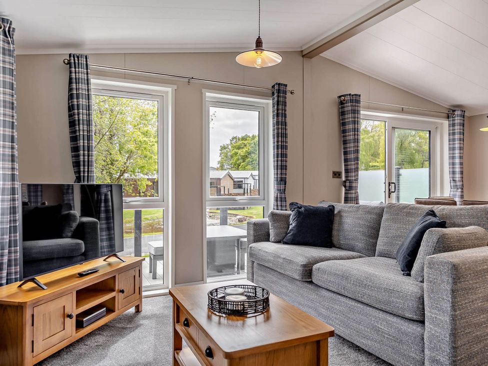 A living room with a sofa and television at Elwy 3.0 Pet in Llandyrnog