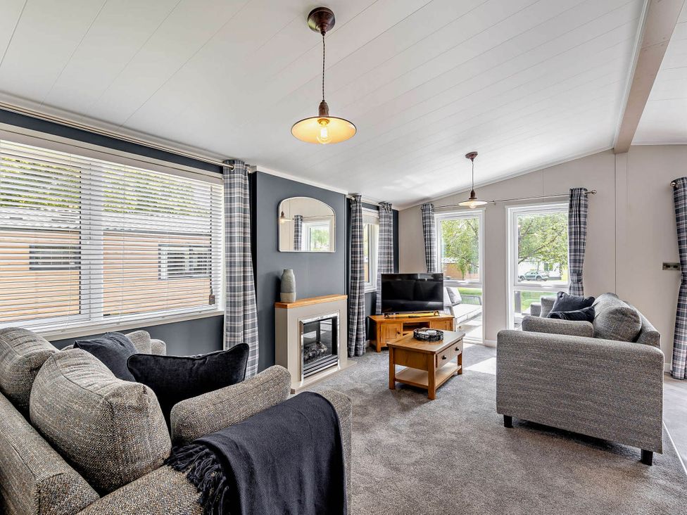 A living room with sofa and television at Elwy 3.0 Pet in Llandyrnog