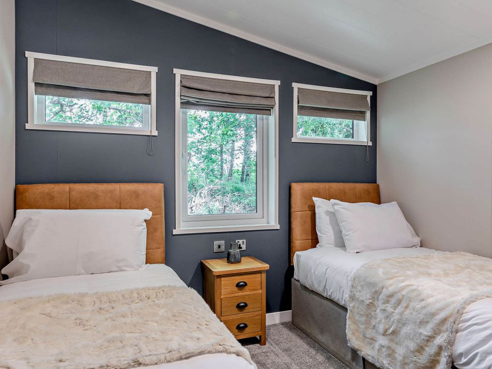 A bedroom with two beds and windows with blinds at Elwy 3.0 Pet in Llandyrnog