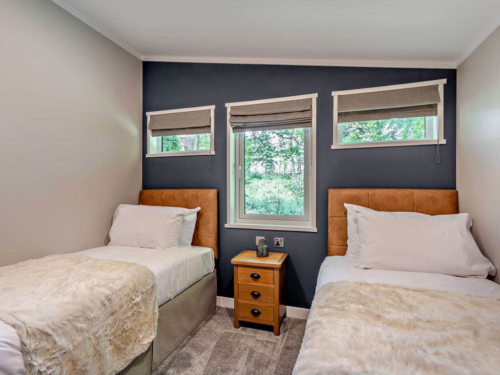 A bedroom with two beds and a nightstand at Elwy 3.0 Pet in Llandyrnog