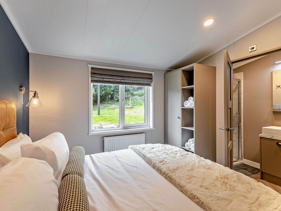A bedroom with a bed and closet at Elwy 3.0 Pet in Llandyrnog