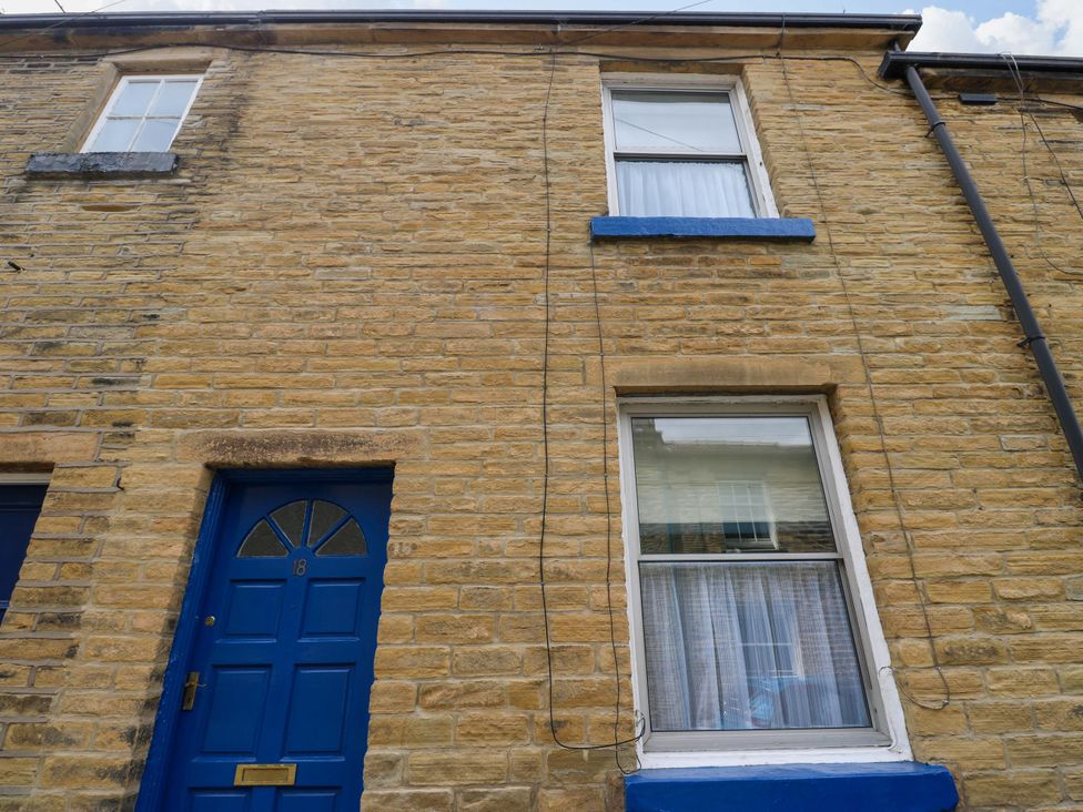 A blue door and window on a brick wall at Saltaire House in Saltaire