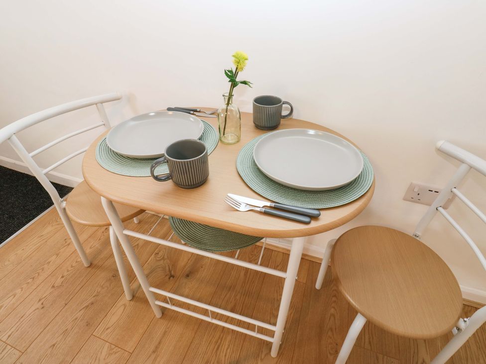 A dining table set with plates and mugs at Saltaire House in Saltaire