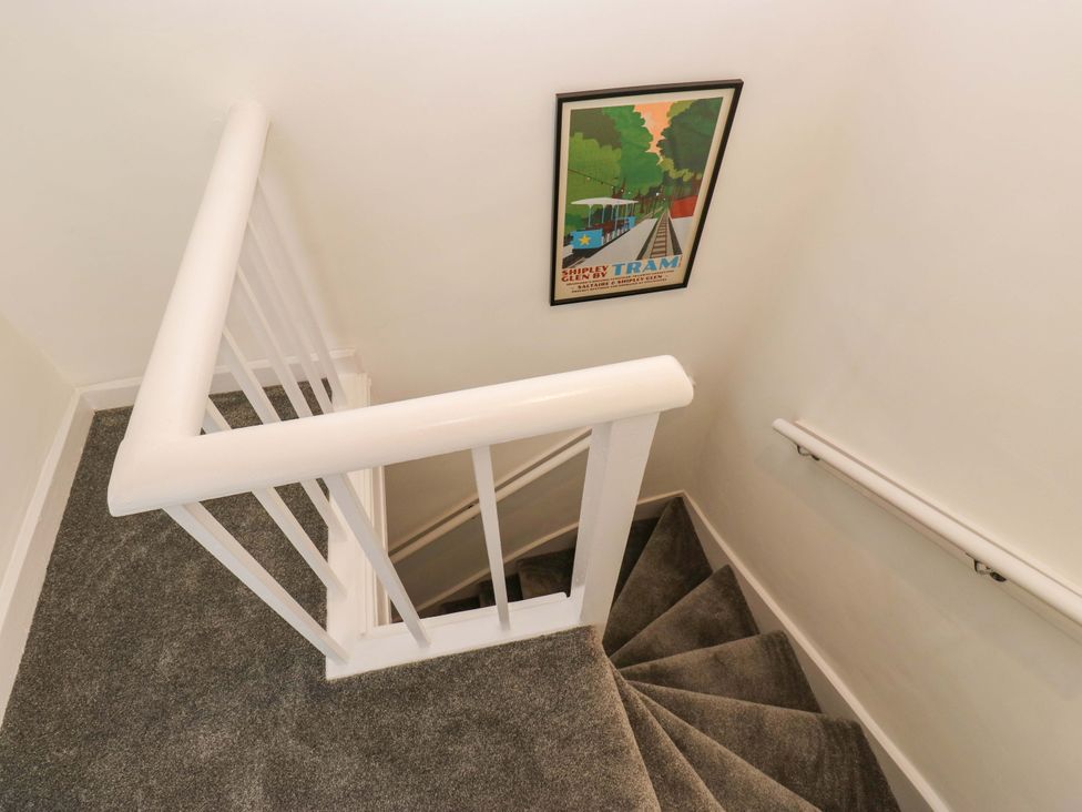 A staircase with a poster on the wall at Saltaire House in Saltaire