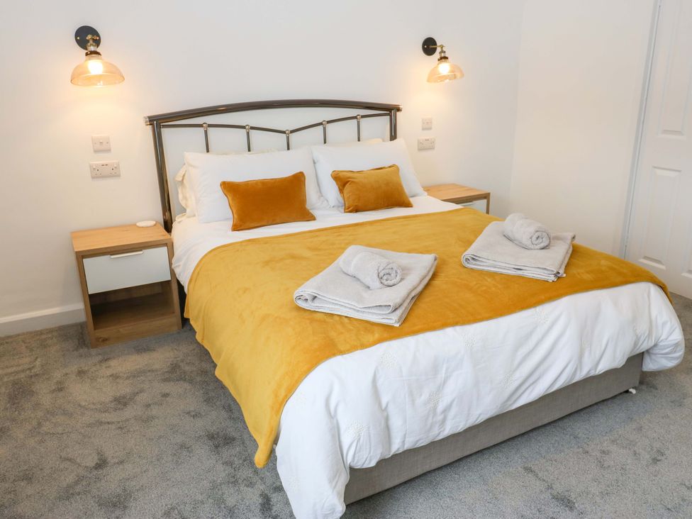 A bedroom with a bed and bedside table at Saltaire House in Saltaire