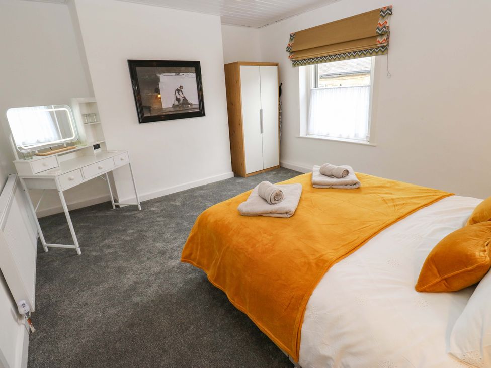 A bedroom with a bed and mirror at Saltaire House in Saltaire