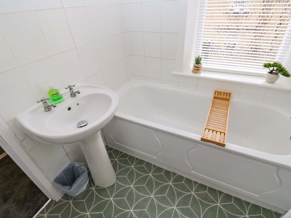 A bathroom with a sink and bath at Saltaire House in Saltaire