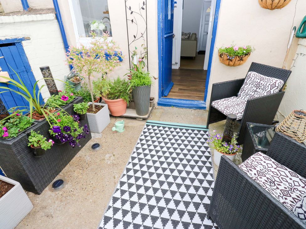 An outdoor seating area with plants and rug at Saltaire House in Saltaire