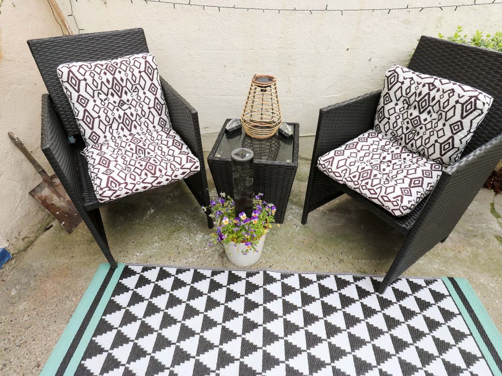 An outdoor seating area with chairs and a small table at Saltaire House in Saltaire