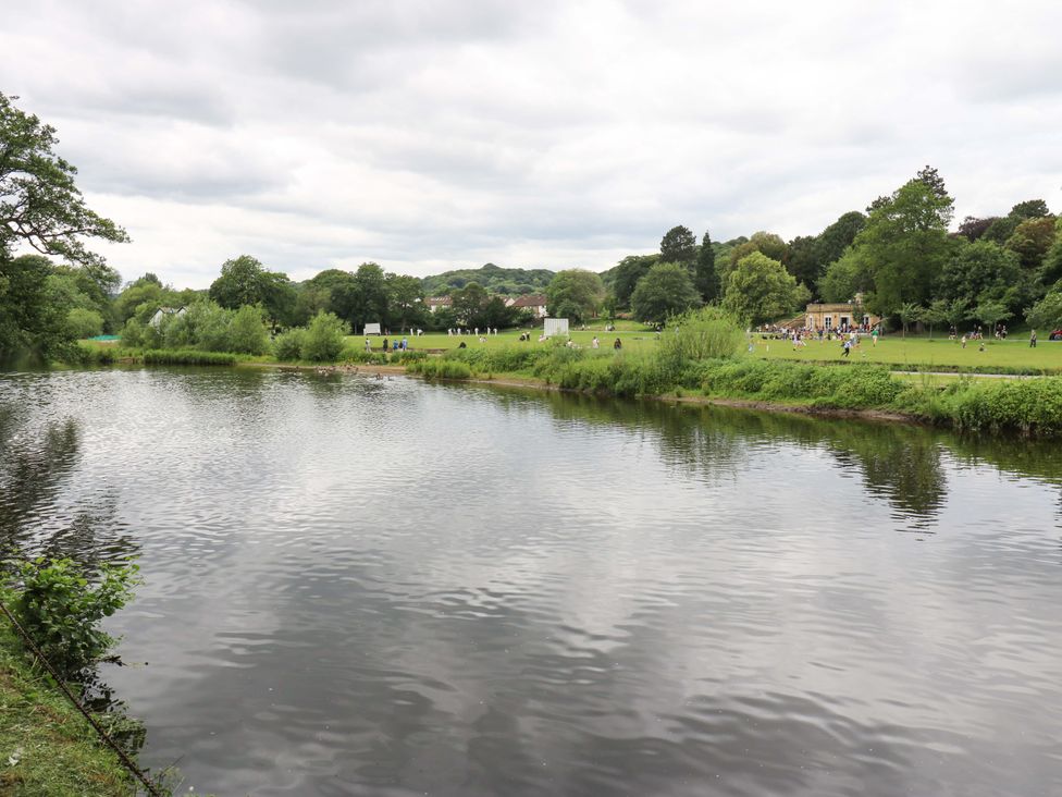 A river with people in a park at Saltaire House in Saltaire