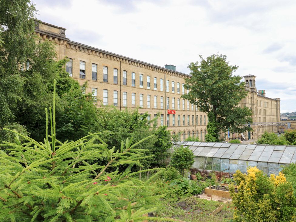 A garden view with buildings and greenhouse at Saltaire House in Saltaire