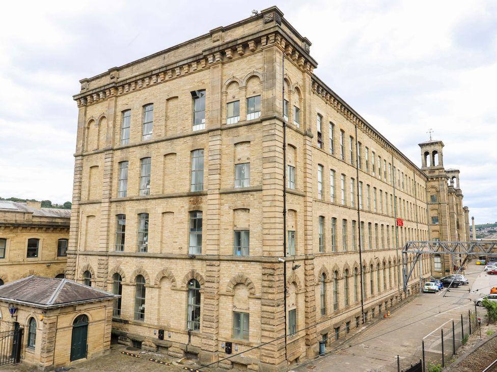 A large building with windows and a pathway outside at Saltaire House in Saltaire