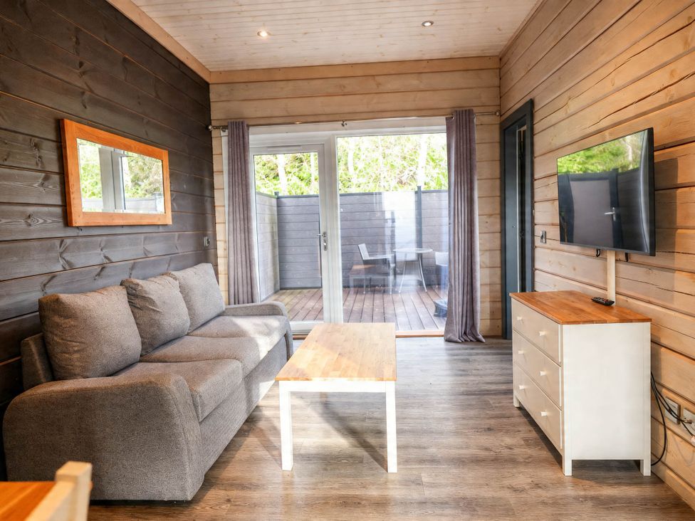 A living room with a sofa, coffee table, and television at Pine Lodge Spa Carlton Miniott near Thirsk