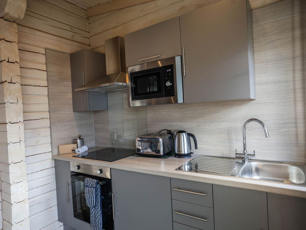 A kitchen with appliances and cabinets at Pine Lodge Spa Pet in Thirsk