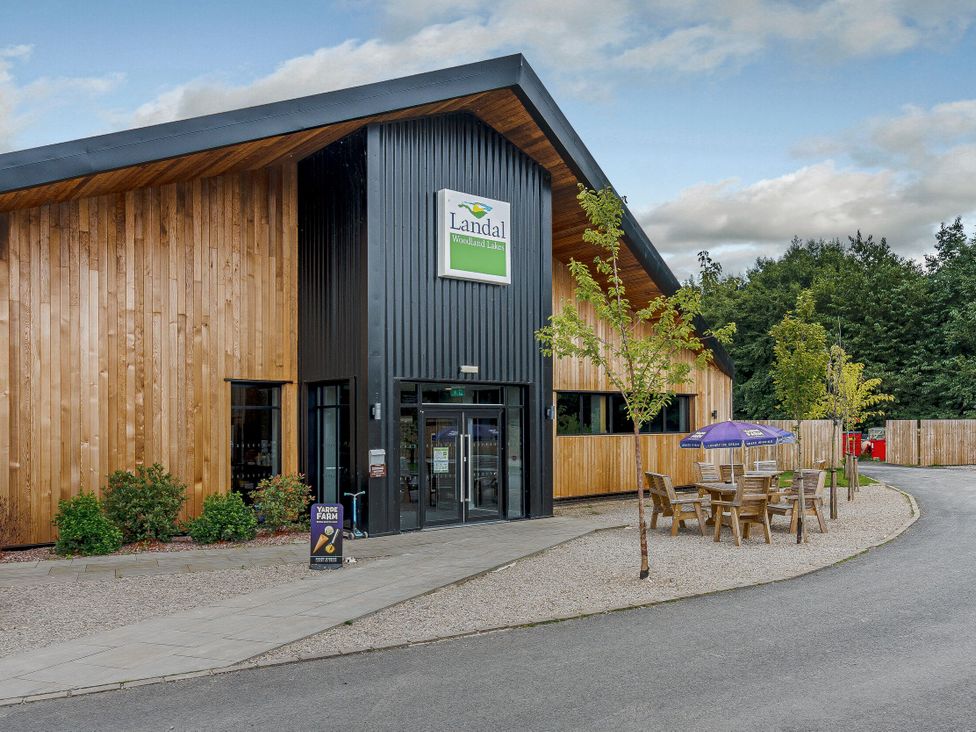 A building entrance with outdoor seating at Landal Woodland Lakes in Thirsk