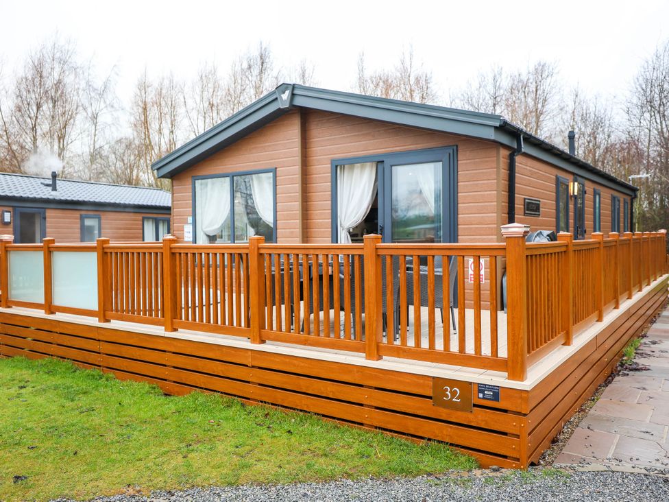 A house with decking and a railing at Laurel Waterside Spa Carlton Miniott near Thirsk