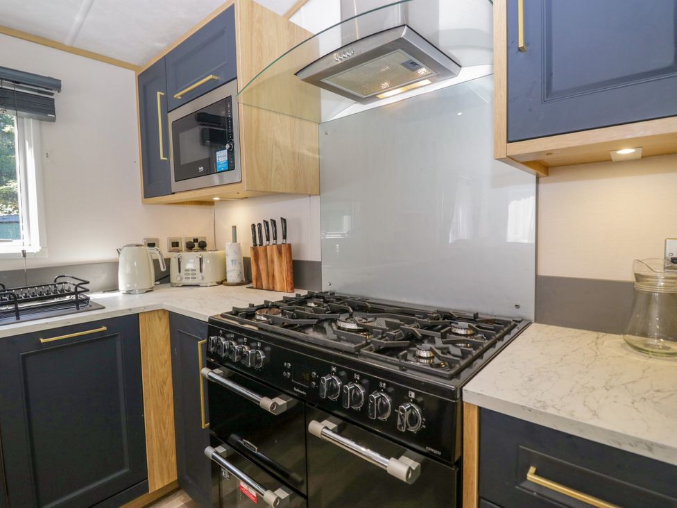 A kitchen with an oven and microwave at 51 Calgarth Park in Troutbeck