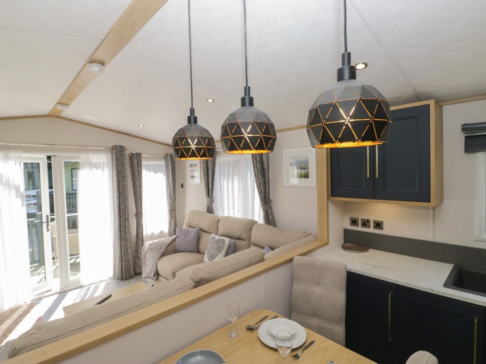 A living room with a sofa and dining table at 51 Calgarth Park in Troutbeck