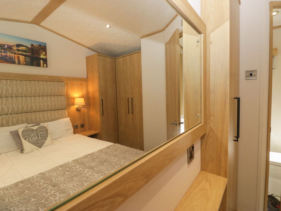 A bedroom with a bed and wardrobe at 51 Calgarth Park in Troutbeck