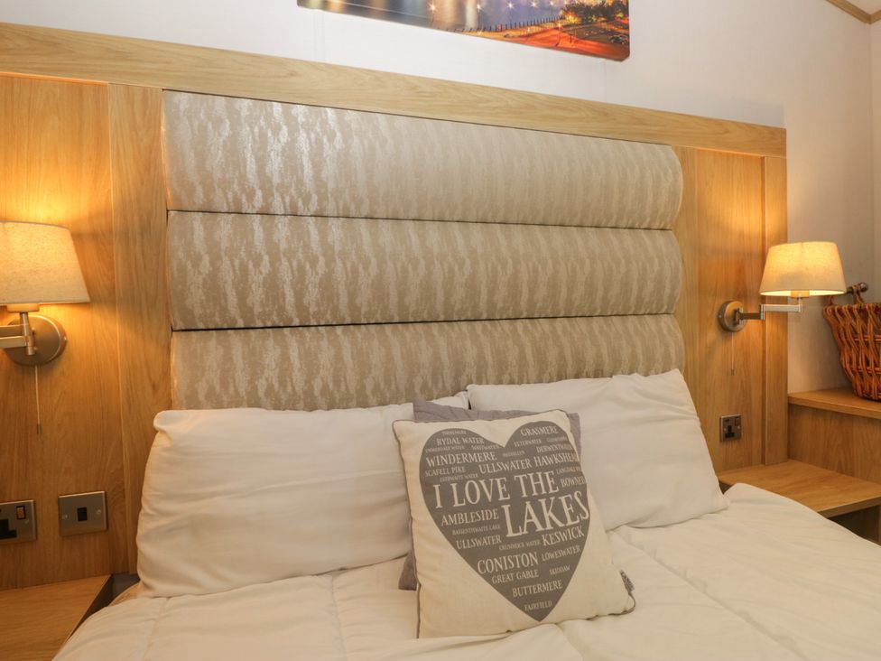 A bedroom with a bed and wall art at 51 Calgarth Park in Troutbeck