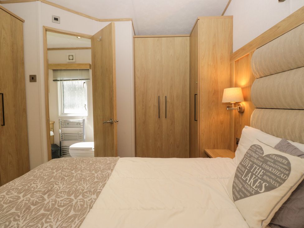A bedroom with a bed and wardrobe at 51 Calgarth Park in Troutbeck