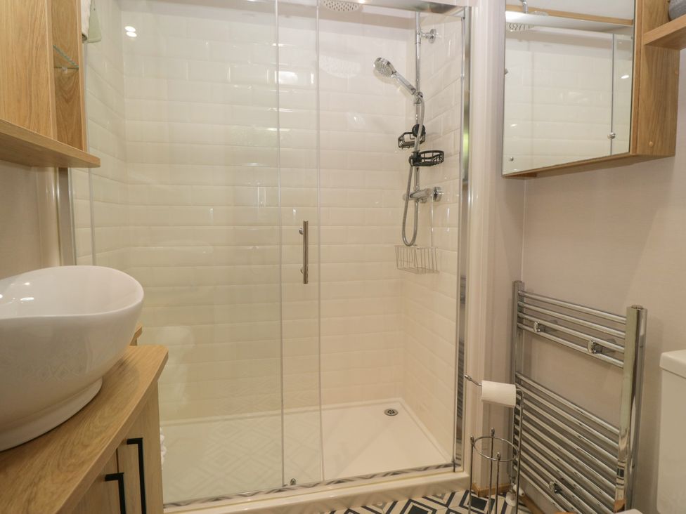 A bathroom with a shower and washbasin at 51 Calgarth Park in Troutbeck