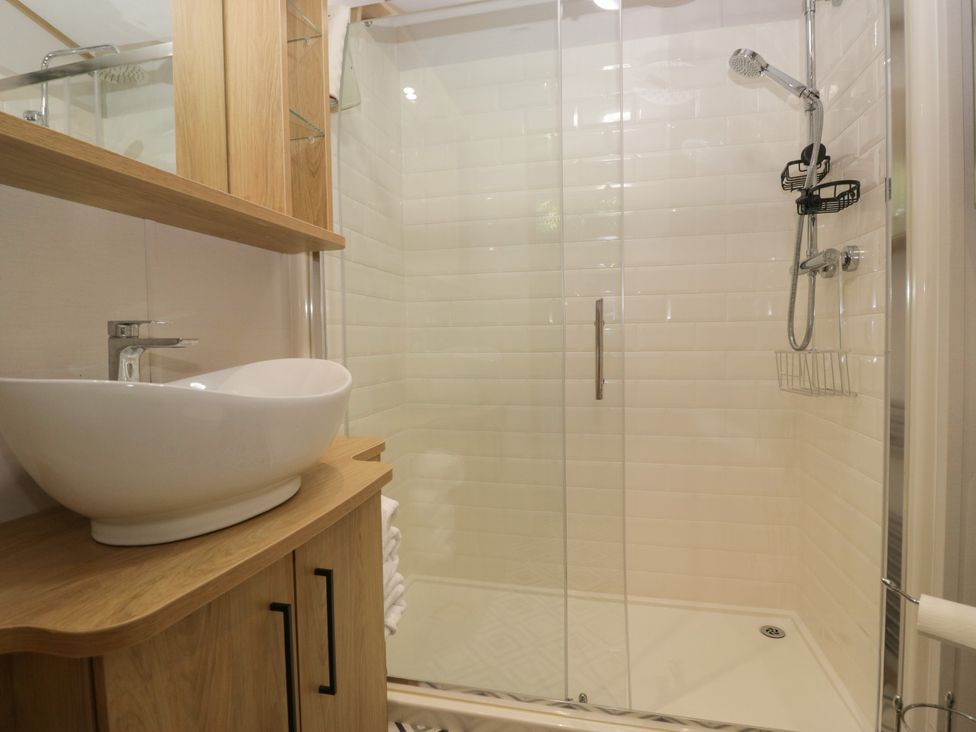 A bathroom with a shower and sink at 51 Calgarth Park in Troutbeck