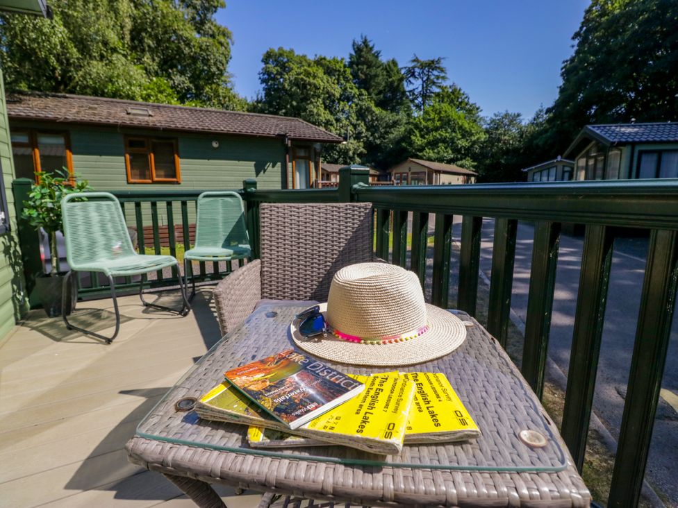 An outdoor seating area with a table, chairs, magazines and a hat at 51 Calgarth Park, Troutbeck